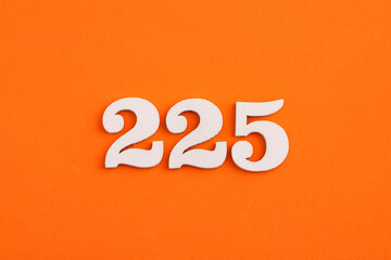 White wooden number 225 on eva rubber orange background
