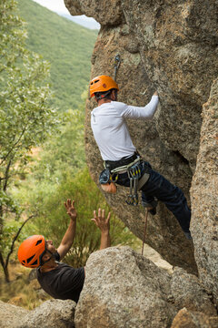 Hikers in equipment climbing mountain with support