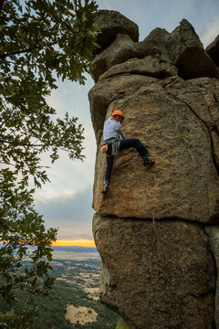 Climber in equipment climbing mountain helping with hand and leg