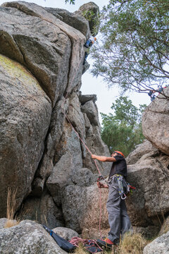 Climber climbing mountain and partner insuring below