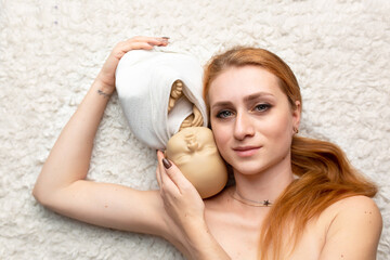 portrait of a mother with a newborn doll. woman with puppet mannequin. baby doll