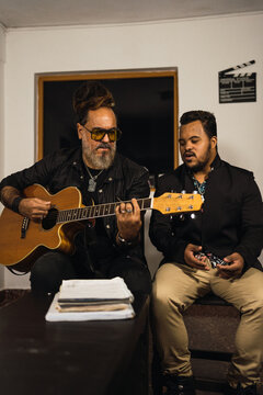 Father and son playing guitar and singing