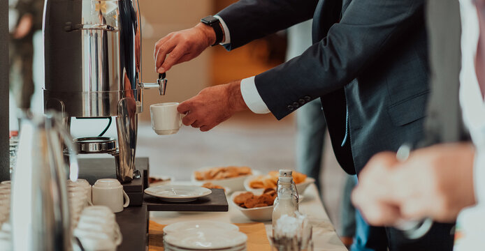 Close-up photo of businessmen serving themselves in a modern hotel during a dinner party. Selective focus