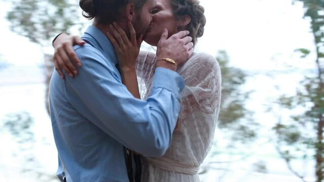 bride and groom exchanging rings and kissing