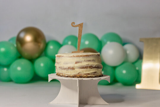 Festive birthday cake with cream near balloons