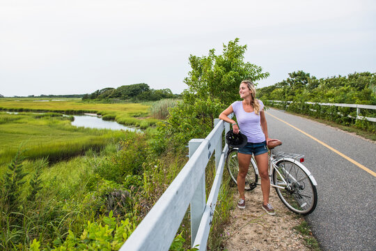 Woman resting on through Cape Cod Marshes bike path