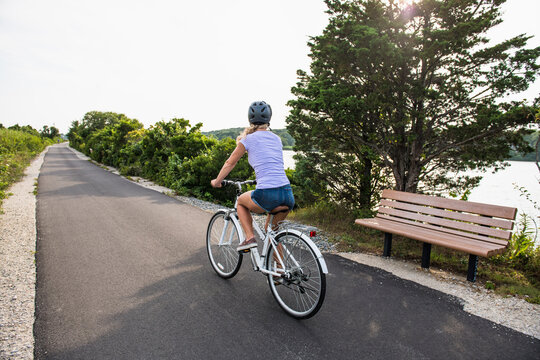 Woman biking through Cape Cod Marshes bike path