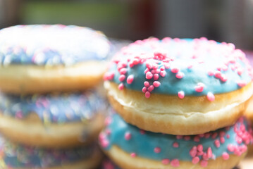 A few doughnuts in blue frosting. The pink sprinkles on the donuts.