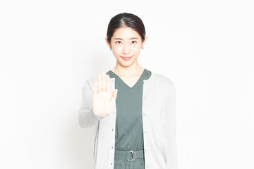 白背景の前でNGのジェスチャーをする女性