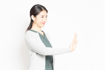 白背景の前でNGのジェスチャーをする女性