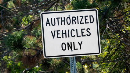 Authorized Vehicles Only street sign on country road. 