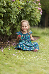 Little girl eating peach and smiling