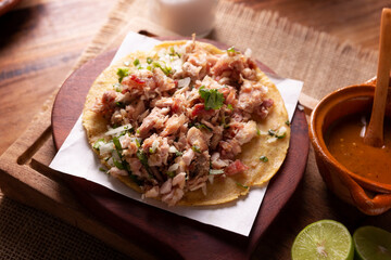 Taco de Carnitas. Cornmeal tortilla with deep fried pork. Traditional Mexican appetizer commonly accompanied by cilantro, onion and hot sauce.