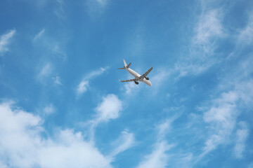 Fototapeta na wymiar Modern airplane flying in blue sky low angle view