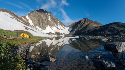 Mountains views in northern Canada during summer time with calm lake and mountain reflection in the...