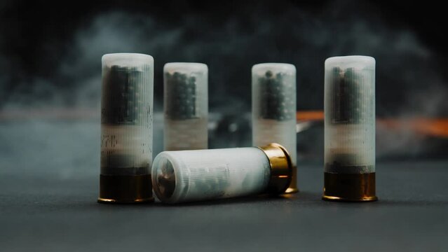 Close-up shotgun shell in smoke against a dark background