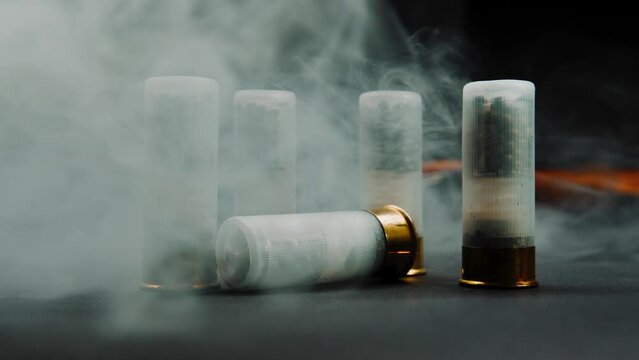 Close-up shotgun shell in smoke against a dark background