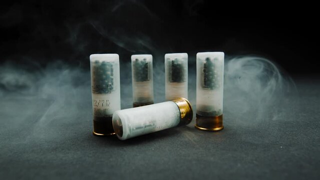 Close-up shotgun shell in smoke against a dark background