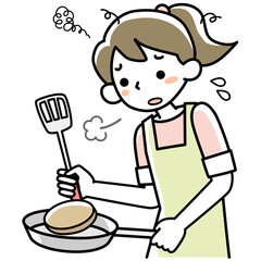 疲れた表情で料理を作る若い女性