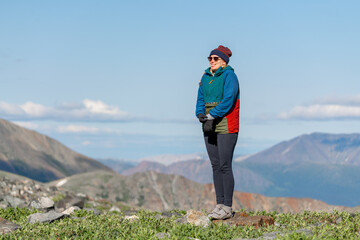 Hiker standing in alpine view area near Yukon Alaska during summer time. 