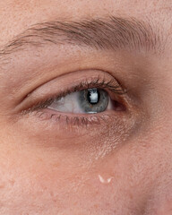 Fototapeta premium eye with a tear flowing down a woman cheek