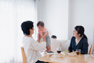 赤ちゃんに高い高いをするお父さん