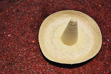 Fototapeta na wymiar Traditional Mexican hat on background of red rocks. Hat in desert.