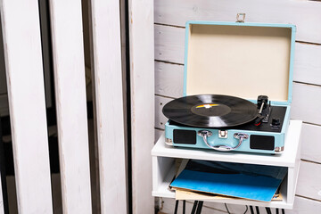 Analog vinyl record player with disc on white table. Modern turn