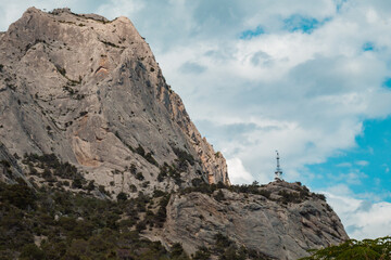 Large rock with green forest around.