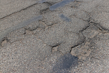 An old paved road with a lot of holes and damage © rsooll