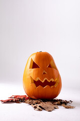 Naklejka premium Composition of halloween jack o lantern, leaves and copy space on white background