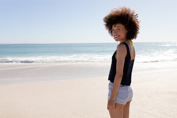 Naklejka premium Mixed race woman standing on the beach