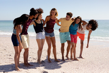 Multi-ethnic group of male and female standing on the beach