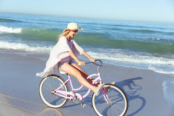 Fototapeta na wymiar Caucasian woman spending time seaside and riding a bike