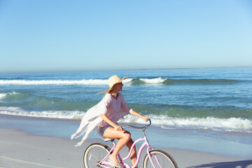 Fototapeta na wymiar Caucasian woman spending time seaside and riding a bike