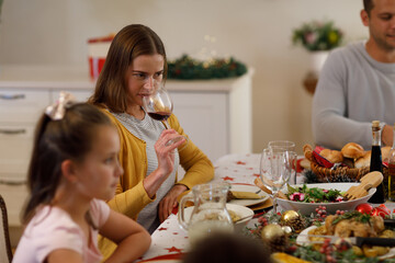 Multi generation caucasian family sitting at table and holding glass of wine
