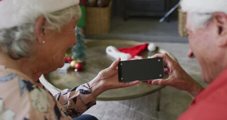 Caucasian senior couple in santa hats on video call on smartphone with copy space at christmas time - Powered by Adobe