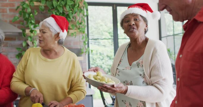 Group Of Happy Diverse Senior Friends Cooking Together In Kitchen At Christmas Time