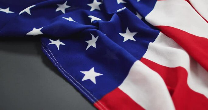 Crumpled american flag with stars and stripes lying on gray background