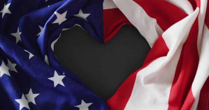Crumpled american flag with heart shape and stars and stripes lying on gray background