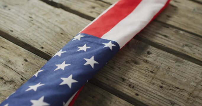 Close up of american flag with stars and stripes lying on wooden background