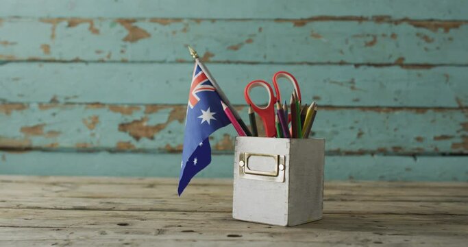Australian flag with stars and stripes with school items on wooden table