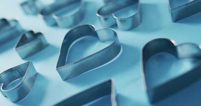 Heart shape cookie cutters on blue background at valentine's day