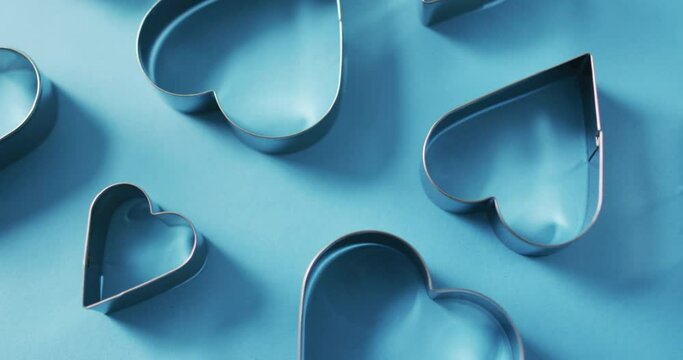 Heart shape cookie cutters on blue background at valentine's day