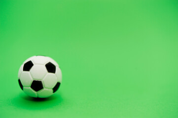 miniature soccer ball over green background
