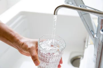 Foto op Plexiglas 浄水器の水をグラスに満たす主婦の手元 © kazoka303030