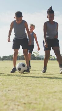 Video of happy diverse boys playing soccer on sports field