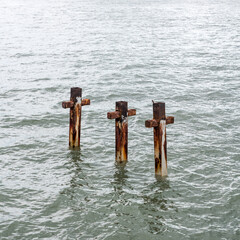 Three rusty metal pylons - remnants of an old jetty in southern Australia