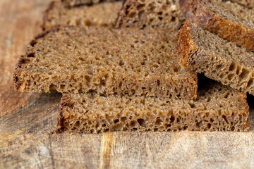 Sliced piece of black rye bread on a board