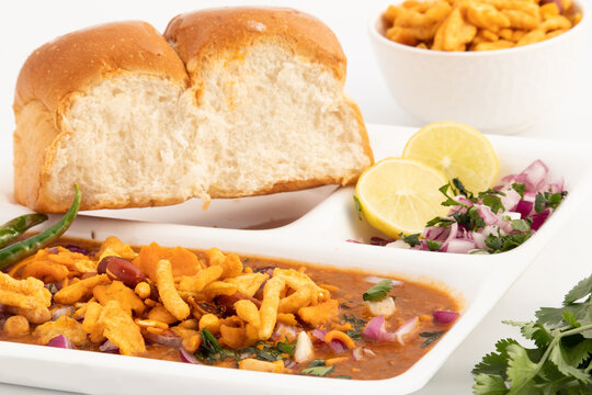 Misal Pav Or Usal Paav Is Famous Maharashtrian Spiced Street Dish. Buns are Served With Spicy Hot Curry Made Of Sprouts Moong Lentils Vegetables, Tomato Onion Grind Paste Puree, Farsan Namkeen Mixture